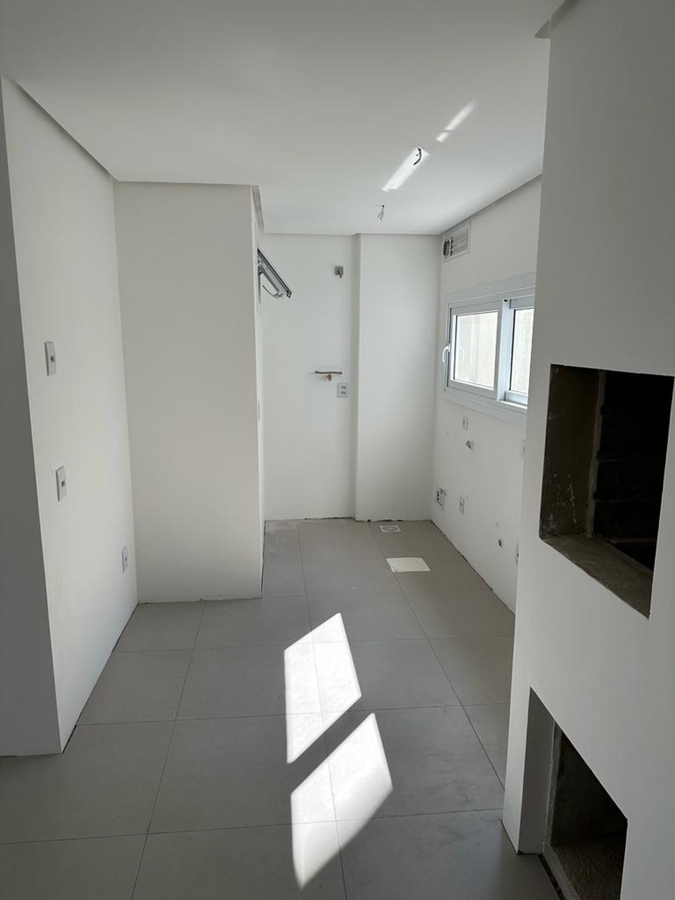 Cozinha com churrasqueira e piso porcelanato